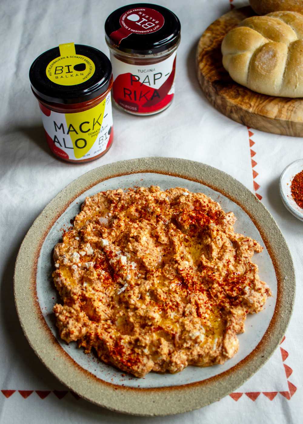 Urnebes, mit Brot, Gläsern und Paprikapulver
