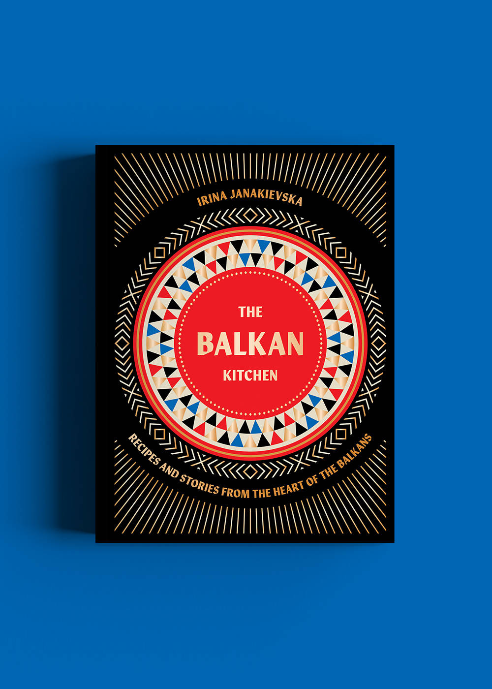 Das Buch The Balkan Kitchen von Irina Janakievska vor blauem Hintergrund