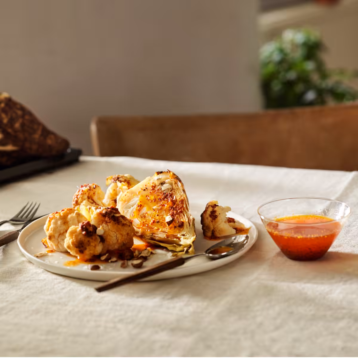Geröstetes Kohlgemüse mit geräuchertem Paprika auf einem mit Tischtuch gedeckten Tisch und Besteck