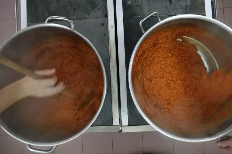 In zwei großen Töpfen wird aus Bio Paprika Ajvar eingekocht.